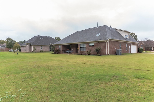 rear view of property with central AC unit and a lawn