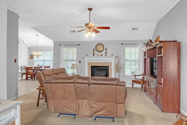 living room with ceiling fan with notable chandelier, crown molding, vaulted ceiling, and light colored carpet