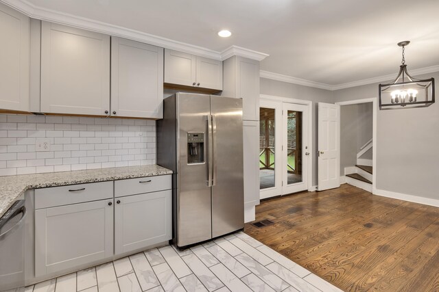 kitchen featuring gray cabinetry, ornamental molding, appliances with stainless steel finishes, light stone countertops, and backsplash