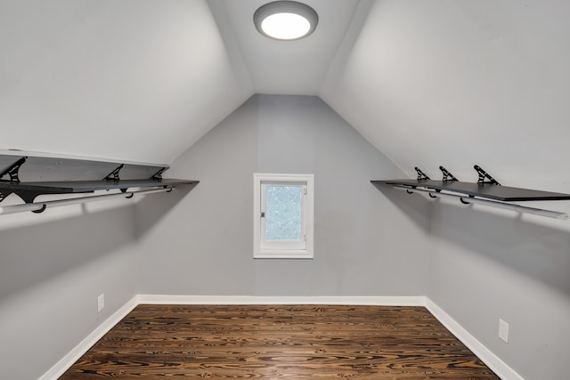 spacious closet with dark wood-type flooring and lofted ceiling