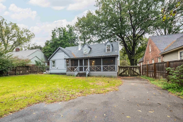 view of front of house featuring a sunroom and a front yard