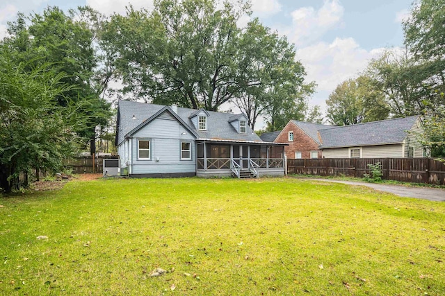 back of property with a sunroom and a lawn