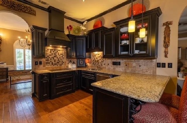 kitchen with crown molding, dark hardwood / wood-style floors, pendant lighting, a breakfast bar, and custom exhaust hood