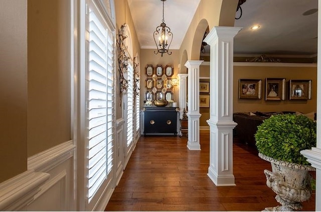 corridor with plenty of natural light, a notable chandelier, crown molding, and dark hardwood / wood-style flooring