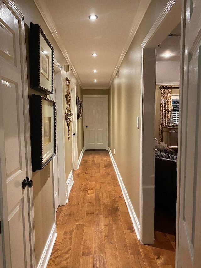 hallway with ornamental molding and hardwood / wood-style flooring