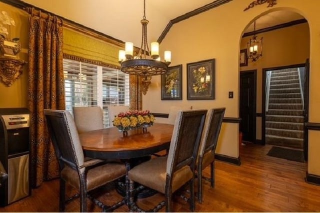 dining area with hardwood / wood-style flooring, vaulted ceiling, and ornamental molding