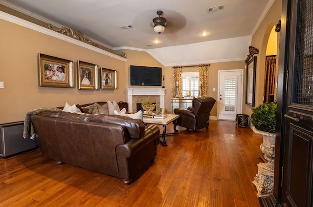 living room with vaulted ceiling, hardwood / wood-style flooring, ceiling fan, and crown molding