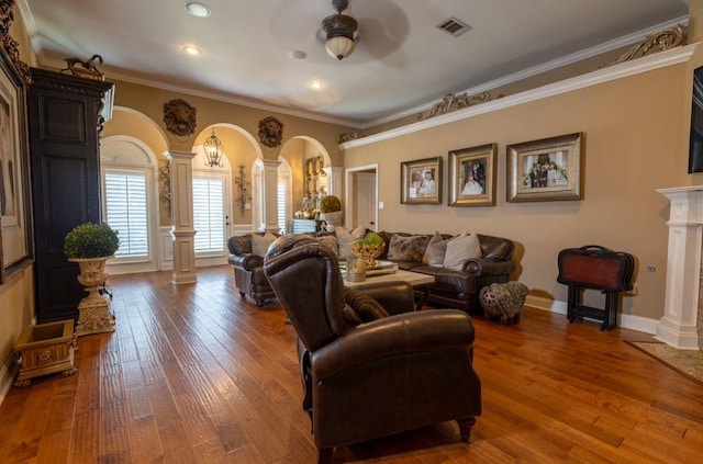 living room with ornamental molding, wood-type flooring, ceiling fan, and ornate columns