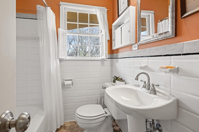 full bathroom featuring tile walls, toilet, shower / bath combination with curtain, and sink