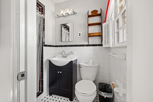 bathroom featuring tile walls, walk in shower, vanity, tile patterned flooring, and toilet