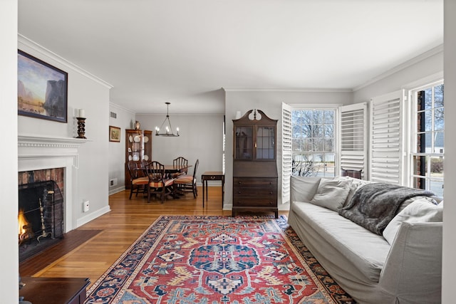 living room featuring wood-type flooring, crown molding, and a notable chandelier