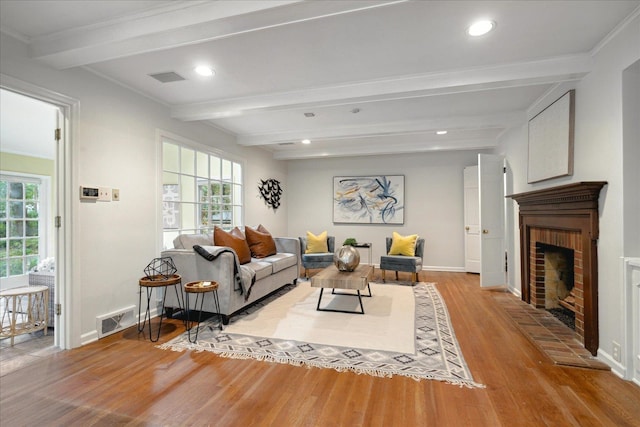 living room with a wealth of natural light, beam ceiling, and light wood-type flooring