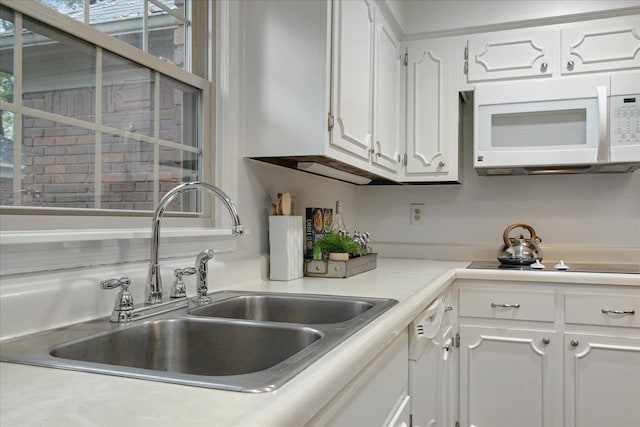 kitchen featuring white cabinetry, sink, and white appliances