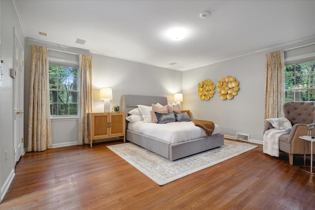 bedroom featuring wood-type flooring and crown molding