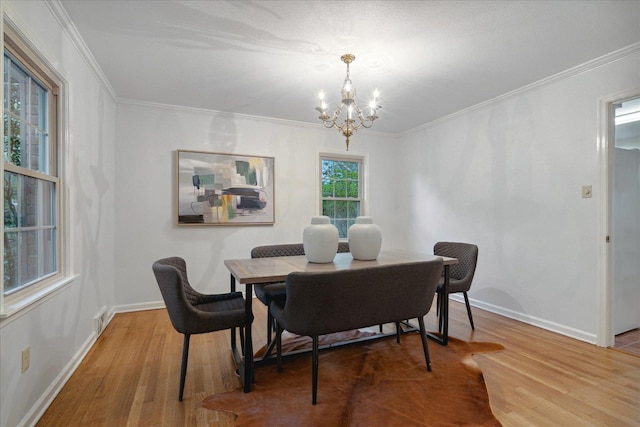 dining space featuring a chandelier, hardwood / wood-style floors, and crown molding