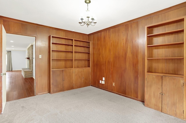 280 Waring Rd, Memphis, TN 38117 - carpeted empty room with a chandelier, wooden walls, crown molding, and built in features