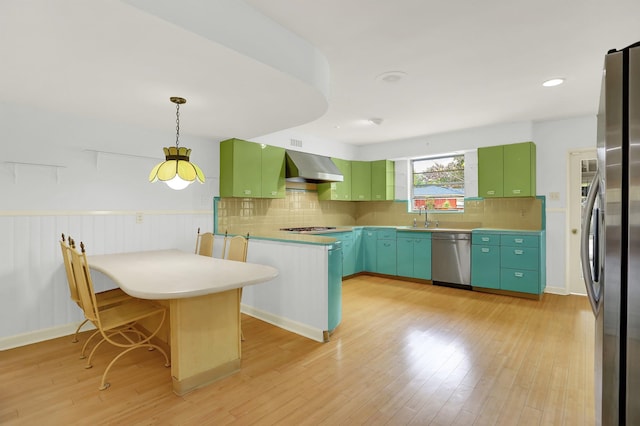 280 Waring Rd, Memphis, TN 38117 - kitchen with appliances with stainless steel finishes, wall chimney range hood, a peninsula, light wood finished floors, and tasteful backsplash
