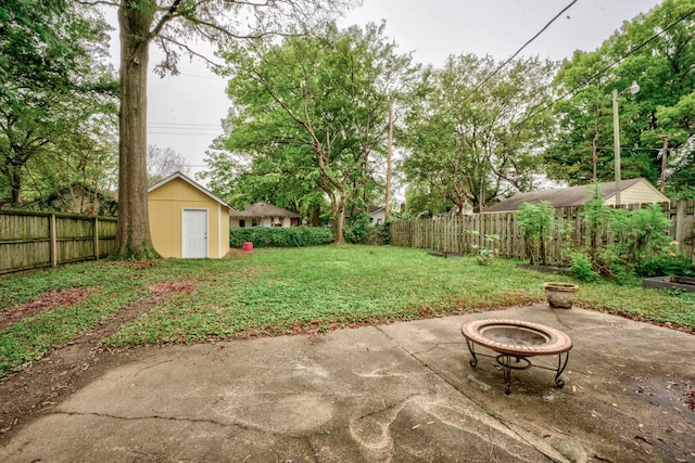 view of yard with a patio, a fire pit, and a storage shed