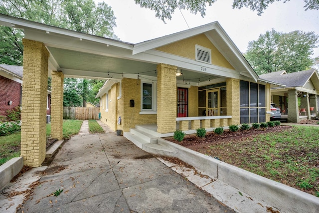 view of front of house featuring a sunroom and a carport