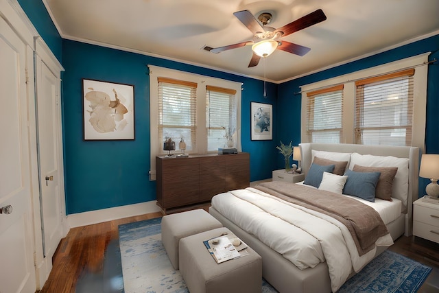 bedroom with ceiling fan, dark hardwood / wood-style floors, and ornamental molding