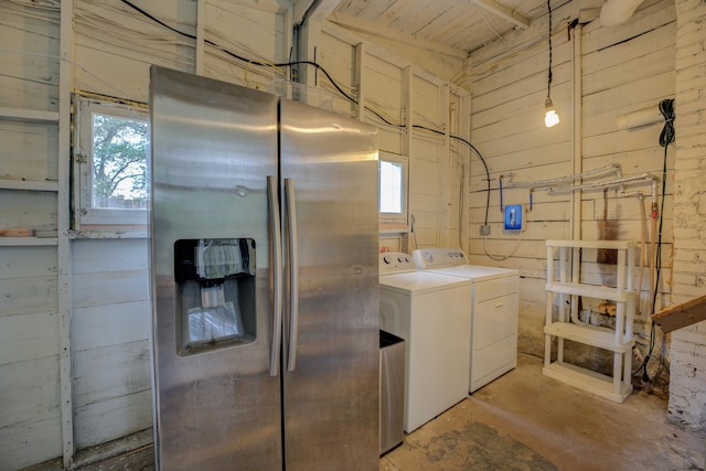 laundry area with independent washer and dryer and wooden walls