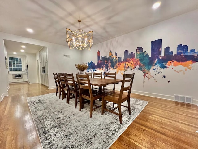 dining space featuring hardwood / wood-style flooring and a notable chandelier