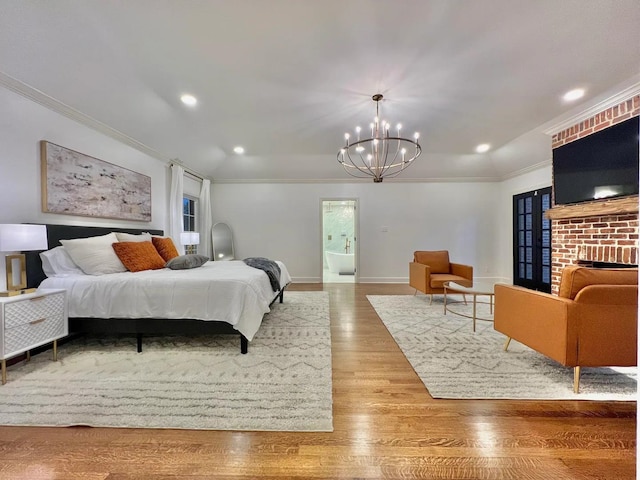 bedroom with a fireplace, wood-type flooring, an inviting chandelier, and crown molding