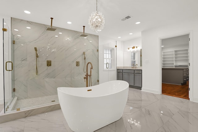 bathroom featuring a notable chandelier, vanity, and plus walk in shower