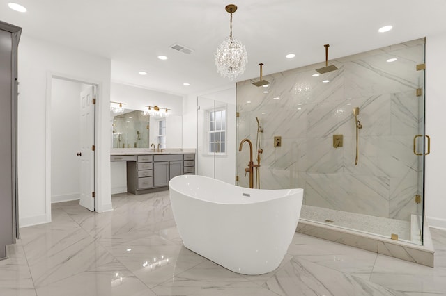 bathroom featuring a chandelier, vanity, and separate shower and tub