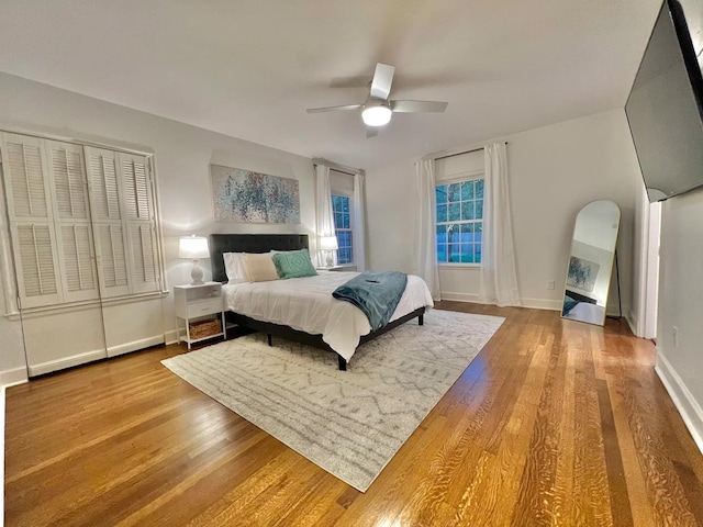 bedroom with a closet, wood-type flooring, and ceiling fan