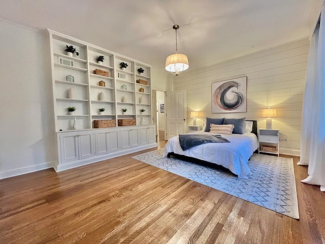 bedroom with wood-type flooring and wooden walls