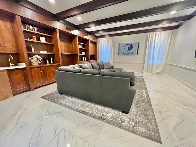 living room with built in features, sink, and beam ceiling