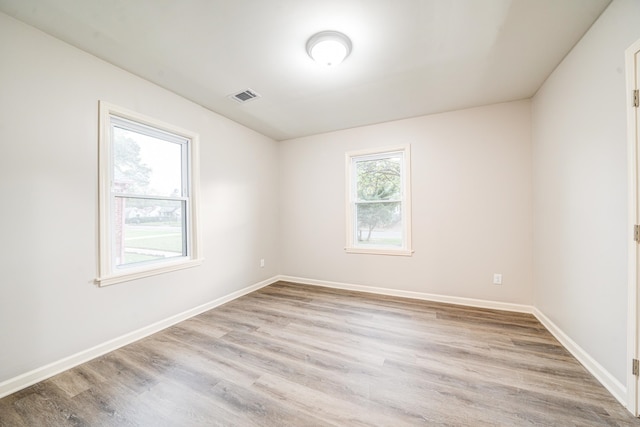 unfurnished room featuring a healthy amount of sunlight and light wood-type flooring