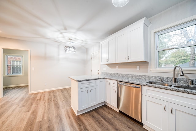 kitchen featuring sink, light stone counters, stainless steel dishwasher, white cabinets, and light wood-type flooring