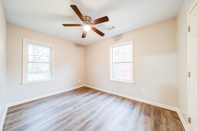 empty room with plenty of natural light, ceiling fan, and light hardwood / wood-style flooring