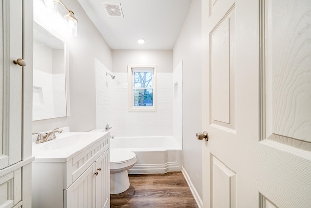 full bathroom featuring wood-type flooring, toilet, vanity, and tiled shower / bath