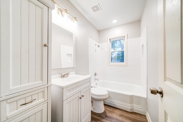 full bathroom with hardwood / wood-style floors, vanity, toilet, and tiled shower / bath