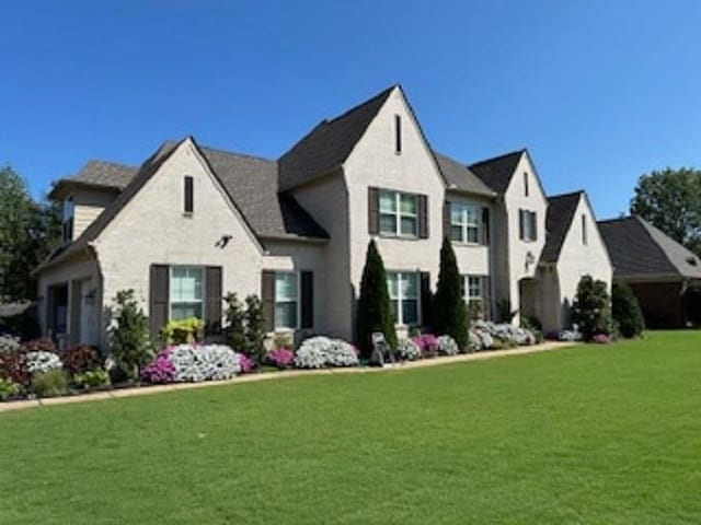 french country style house featuring a front lawn