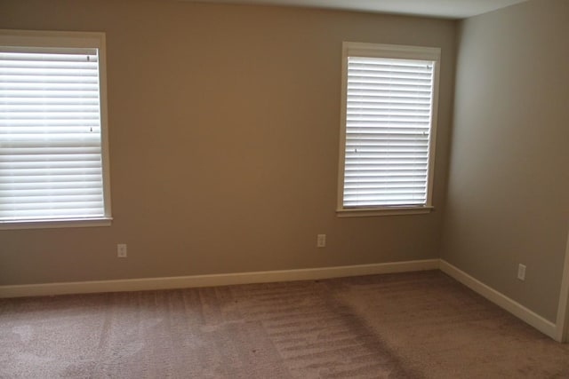 carpeted spare room featuring a healthy amount of sunlight