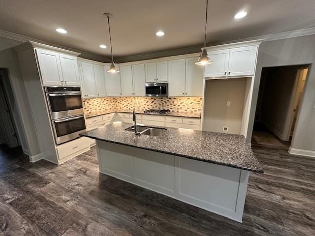 kitchen with stainless steel appliances, white cabinetry, sink, dark stone counters, and dark hardwood / wood-style flooring