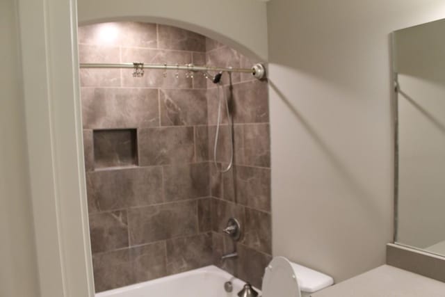 full bathroom featuring toilet, tiled shower / bath combo, and vanity