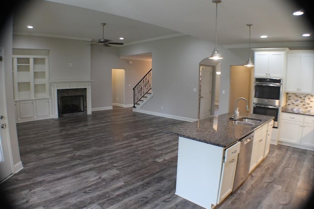 kitchen featuring dark stone counters, sink, dark hardwood / wood-style floors, white cabinetry, and appliances with stainless steel finishes