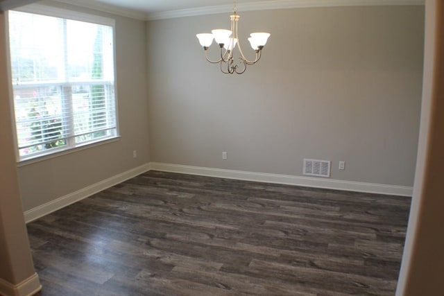 empty room with dark wood-type flooring, crown molding, and a notable chandelier