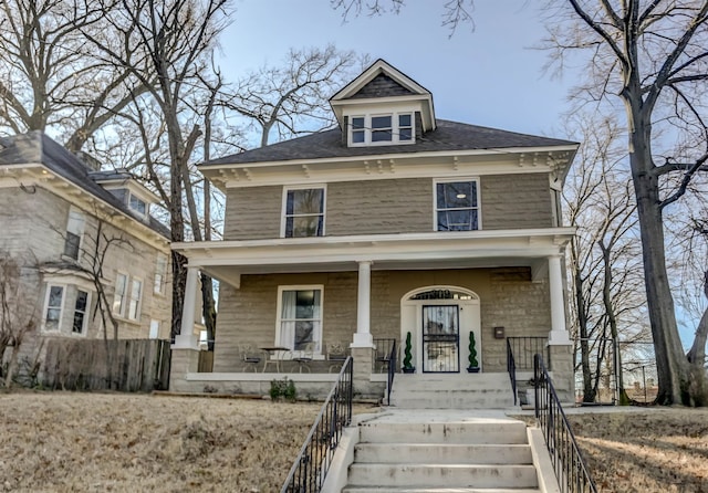 traditional style home featuring a porch and fence