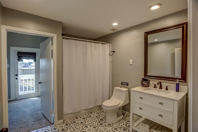 bathroom featuring toilet, vanity, and a shower with shower curtain