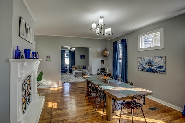 dining room featuring a wealth of natural light, hardwood / wood-style flooring, and crown molding