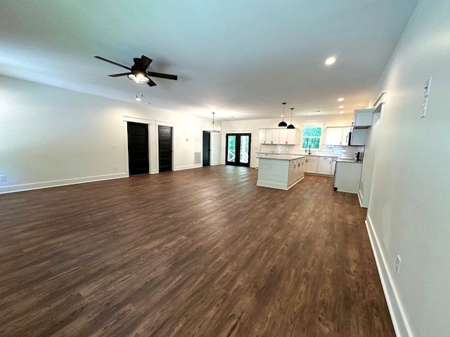 unfurnished living room with ceiling fan and dark hardwood / wood-style floors