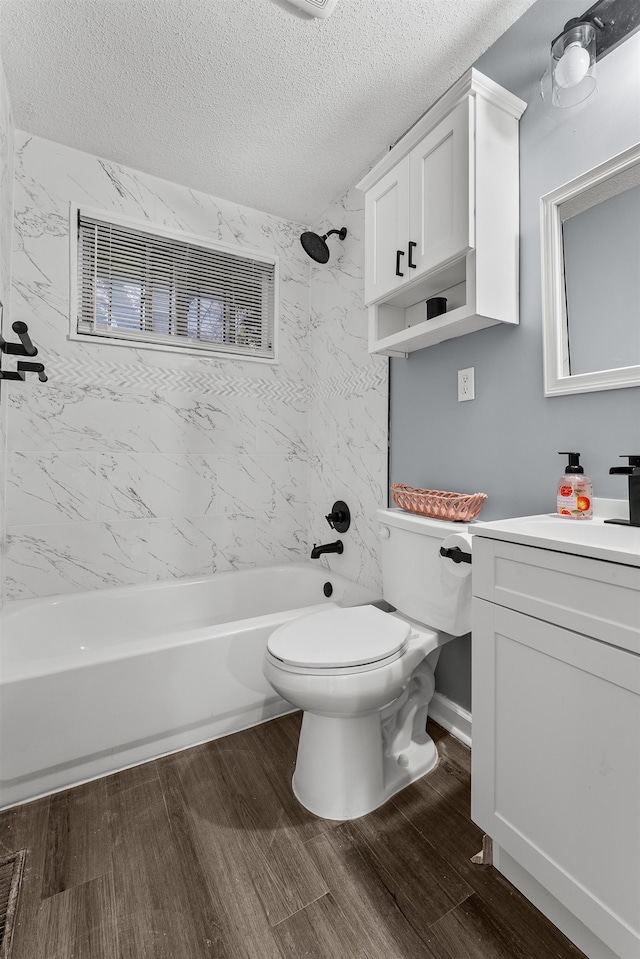 full bathroom with hardwood / wood-style floors, tiled shower / bath, a textured ceiling, and vanity