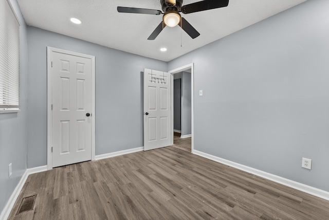 unfurnished bedroom with ceiling fan and light hardwood / wood-style flooring