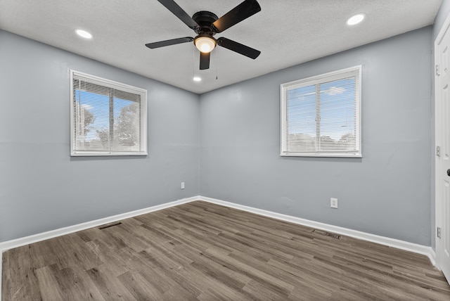 spare room featuring wood-type flooring, ceiling fan, and a textured ceiling